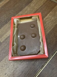 a chocolate 1 cm thick and 10 with 15 cm whide. On the top there are big braille dots in the shape of a t. 