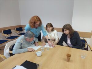 An employee from the library helps participants during a discussion with the lead coordinator of the Braille Authority of Slovakia, Michal Tkáčik, to feel pictures in relief graphics from SKN.