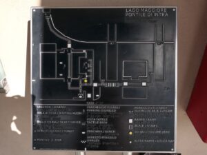 A black square plaque features a silver-colored relief map of the harbor in Verbania on Lake Maggiore.