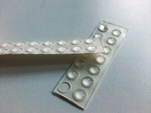 On a table, there are transparent raised-dot stickers.