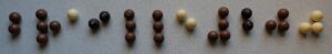 a photo of our “Braille 200” lettering, laid out with delicious chocolate balls.